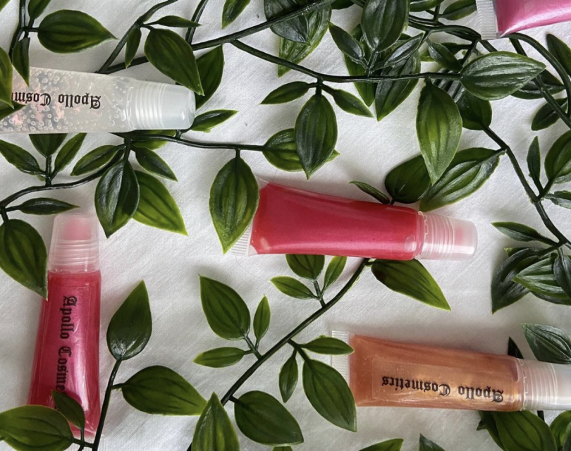 Apollo Cosmetics' lip glosses laid out on green leaves